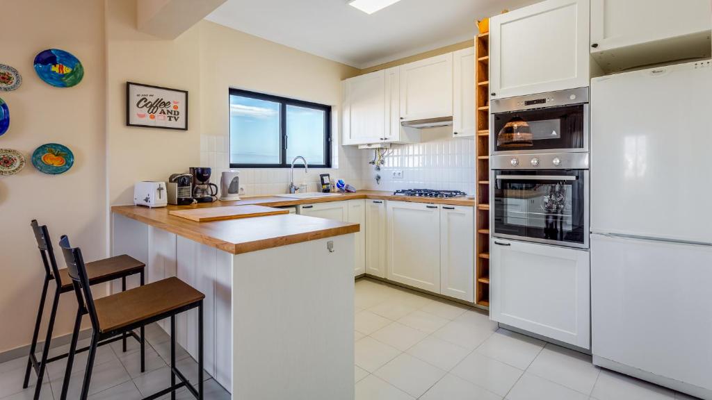a kitchen with white cabinets and white appliances at Casa Brasil 2 BDR With Balcony by LovelyStay in Portimão
