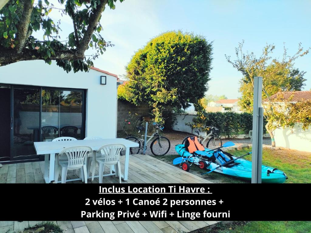 een huis met een motorfiets geparkeerd naast een tafel bij Maison Ti Havre avec jardin privé dans village de pêcheurs à Brem sur mer ! in Brem-Sur-Mer