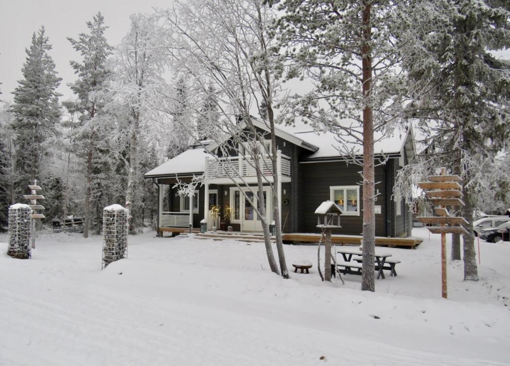 a cabin in the snow with a snow covered yard at B&B Adventures in Äkäslompolo