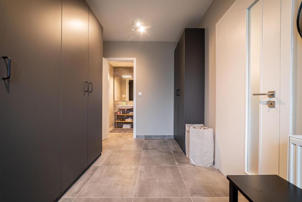 a hallway with a door and a room with a table at Trio Harrachov in Harrachov