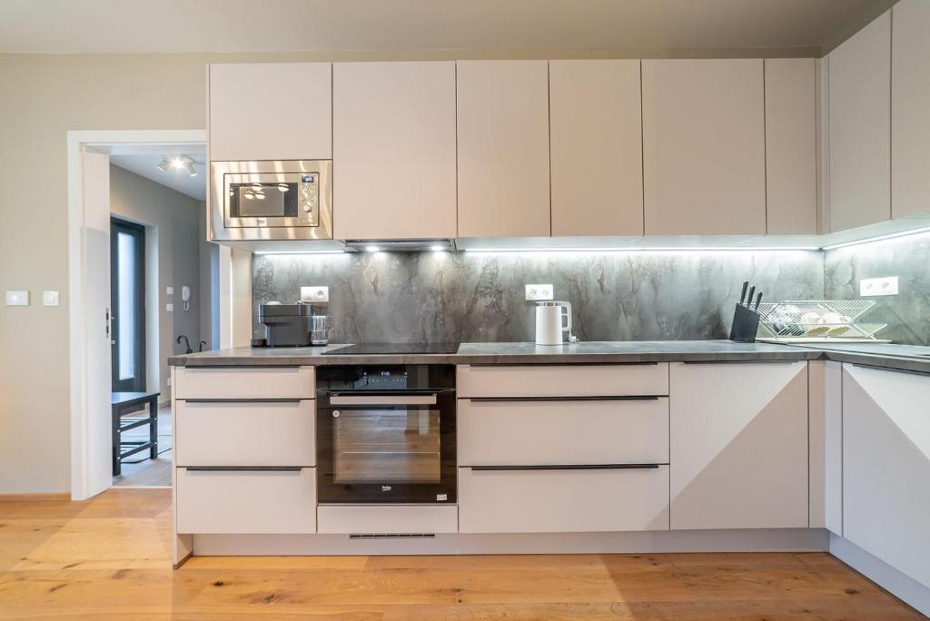 a kitchen with white cabinets and a stove top oven at Trio Harrachov in Harrachov
