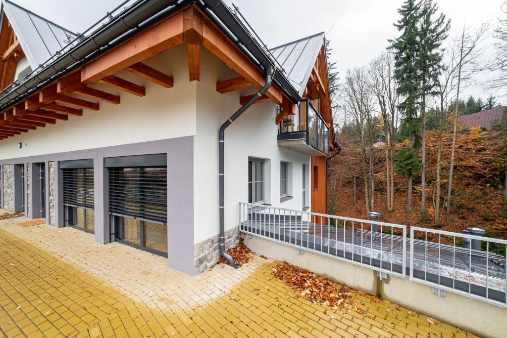 a house with a balcony on the side of it at Trio Harrachov in Harrachov