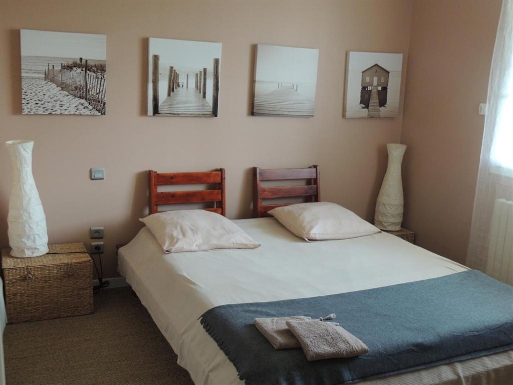a bedroom with a bed and pictures on the wall at Le Gîte de la Bade in Villegailhenc