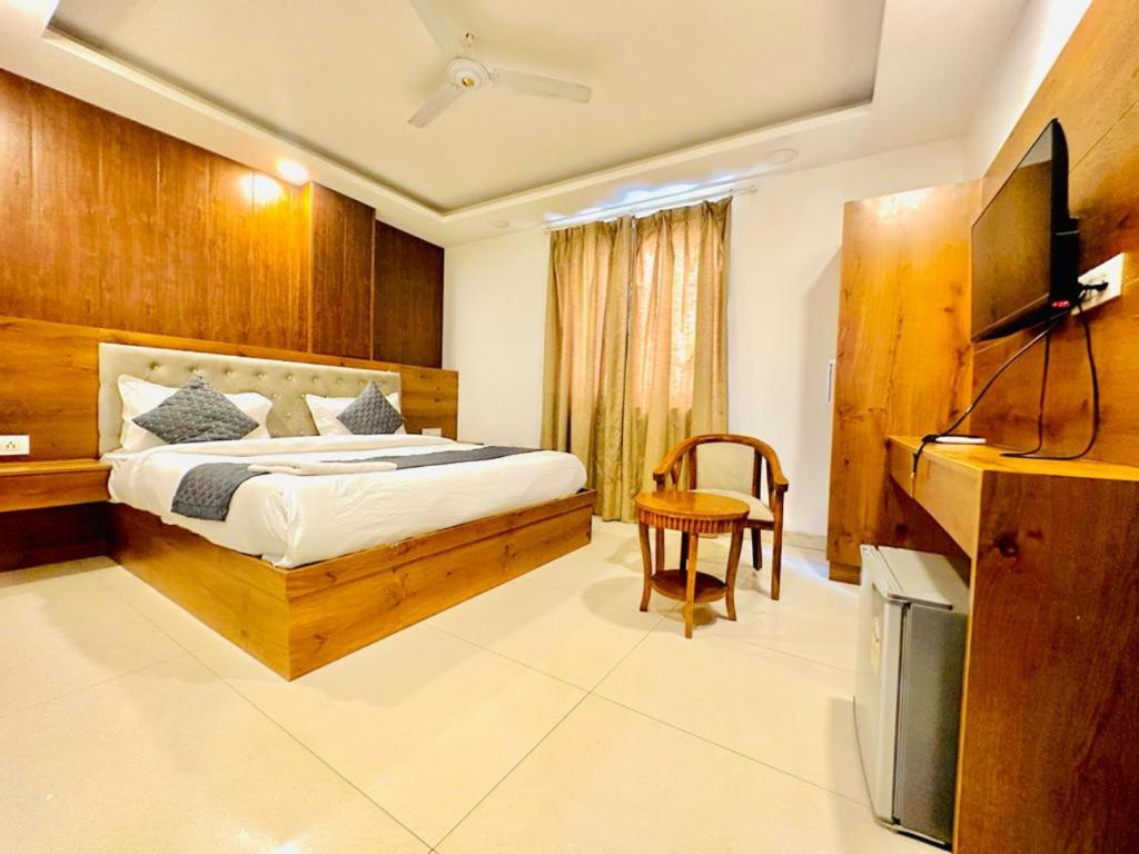 a bedroom with a bed and a television in it at Hotel The Glory Near Delhi International Airport in New Delhi