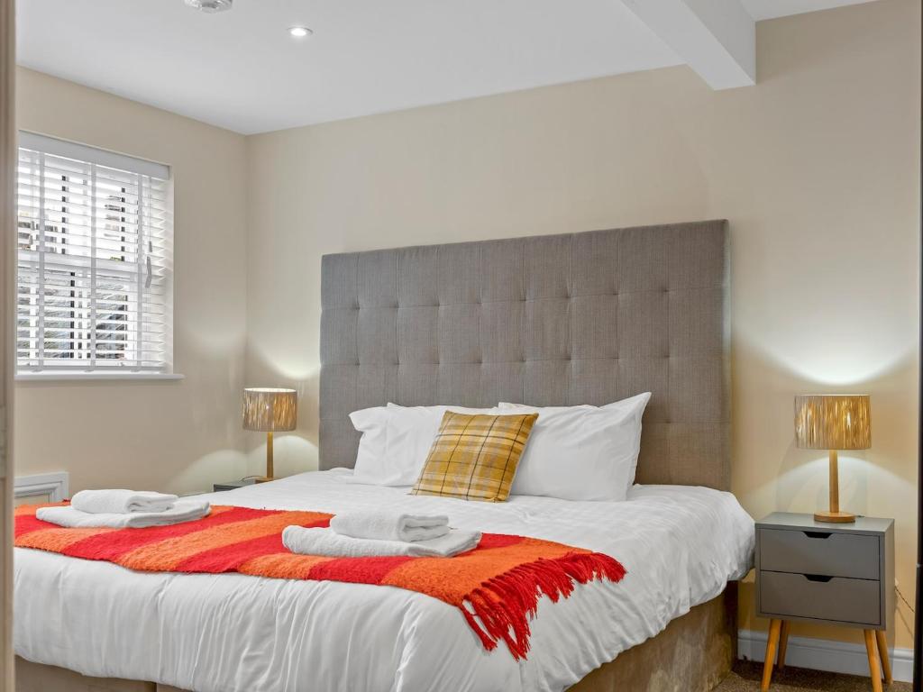 a bedroom with a large bed with two lamps at Pass the Keys Newly Renovated 2 Bedroom Town Centre Apartment in Ulverston