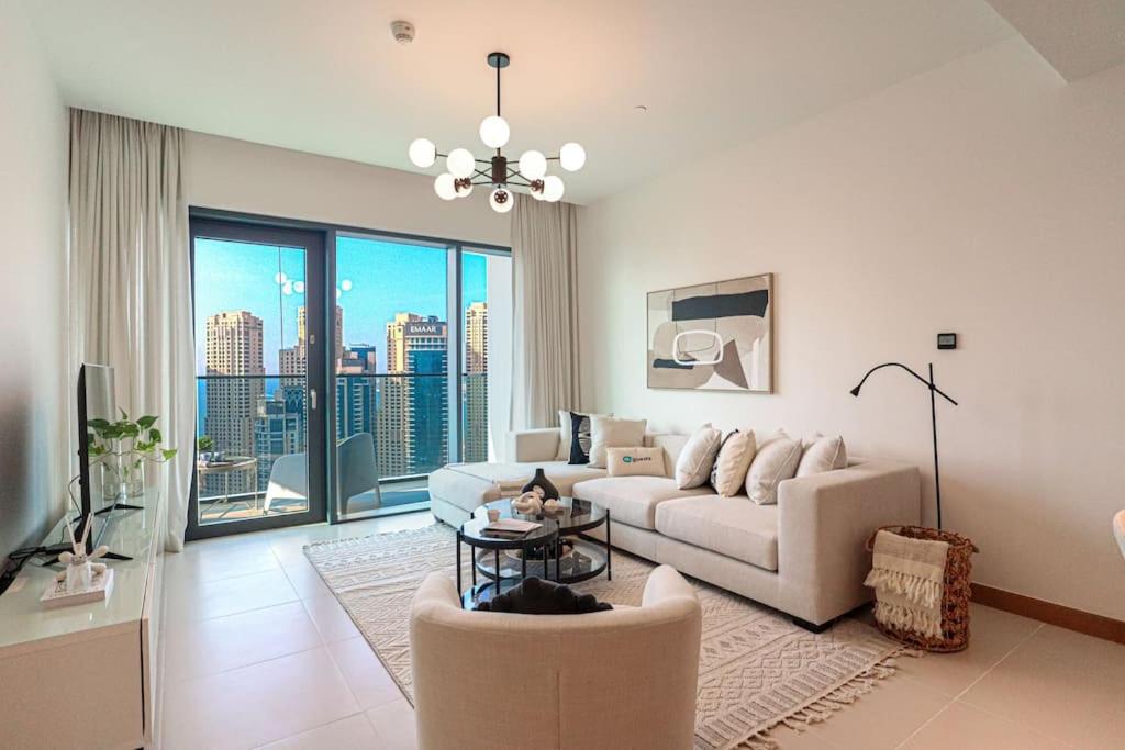 a living room with a couch and a table at HiGuests - High Level Luxury Apartment With Marina Views in Dubai
