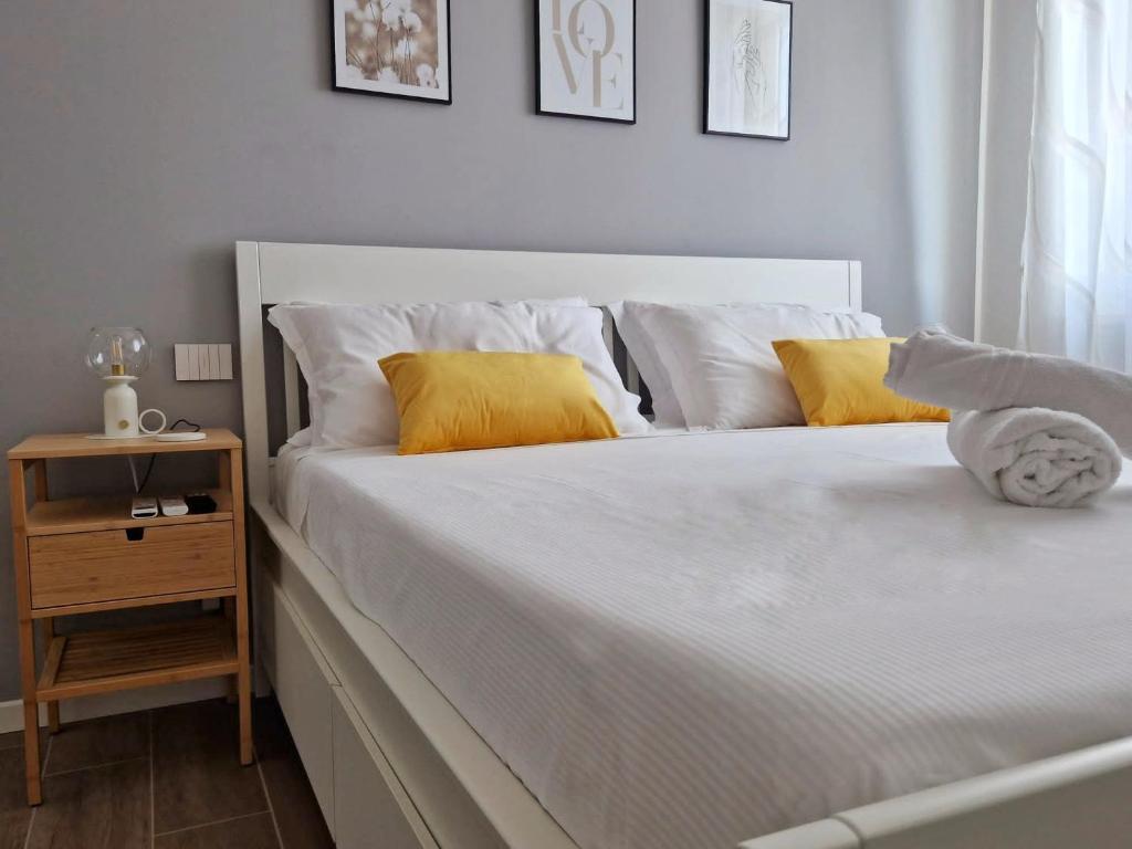 維洛納的住宿－MARCO POLO APARTMENT，白色的床,配有白色床单和黄色枕头
