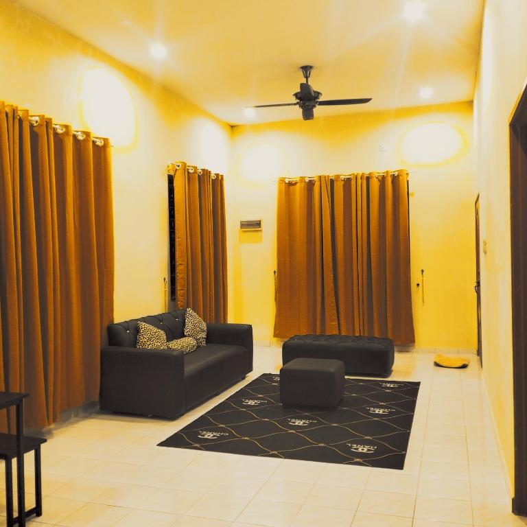 ein Wohnzimmer mit einem Sofa und einem Teppich in der Unterkunft Rezqrich Villa Homestay 1 in Kampung Degong