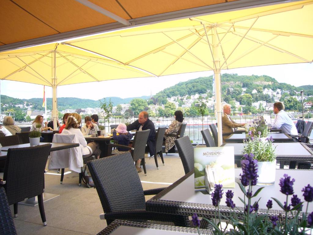 a group of people sitting at tables in a restaurant at RheinHotel ARTE in Remagen