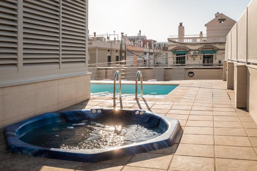 bañera de hidromasaje al lado de un edificio en Sunotel Club Central, en Barcelona