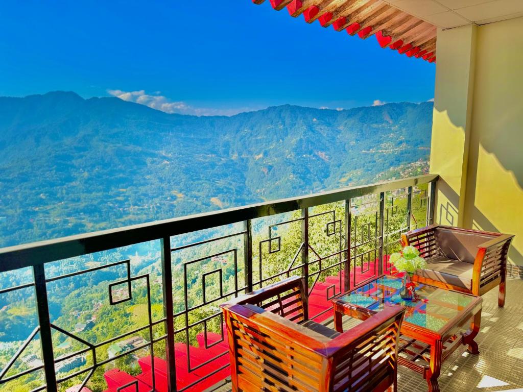balcón con mesa, sillas y vistas en Tara Palace Resort and SPA, en Gangtok