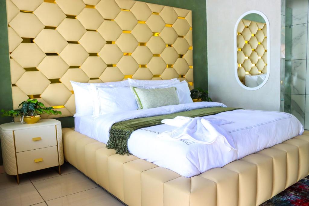 a bed with a large padded headboard in a bedroom at Suite Boutique Lodge in Pretoria