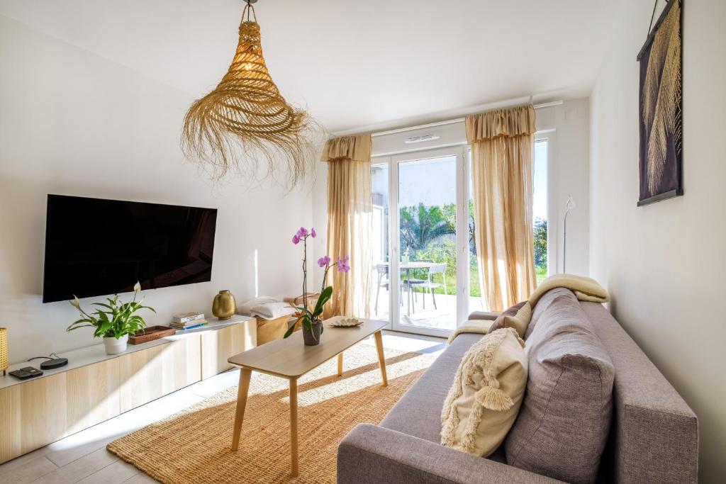 un salon avec un canapé et une télévision dans l'établissement Le Jasmin, à Nice
