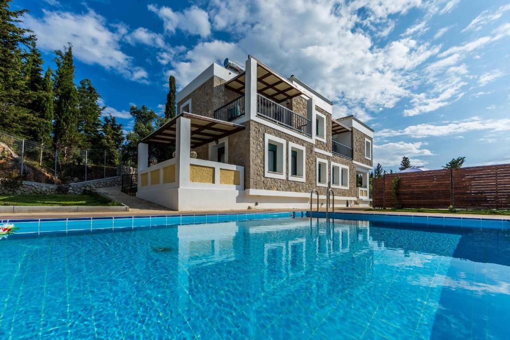 a house with a swimming pool in front of it at Villa Vera in Agios Nikitas