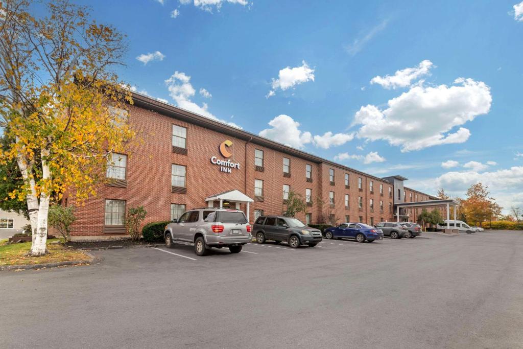 a large brick building with cars parked in a parking lot at Comfort Inn Airport in South Portland