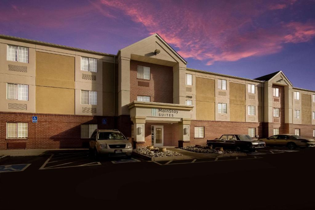 a large building with cars parked in a parking lot at MainStay Suites Denver Tech Center in Centennial