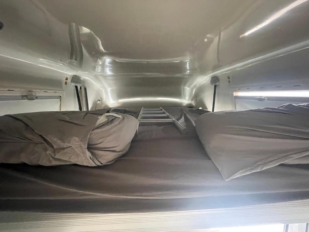Una vista interior de una caravana con dos camas. en Campers Reyna, en Arrecife
