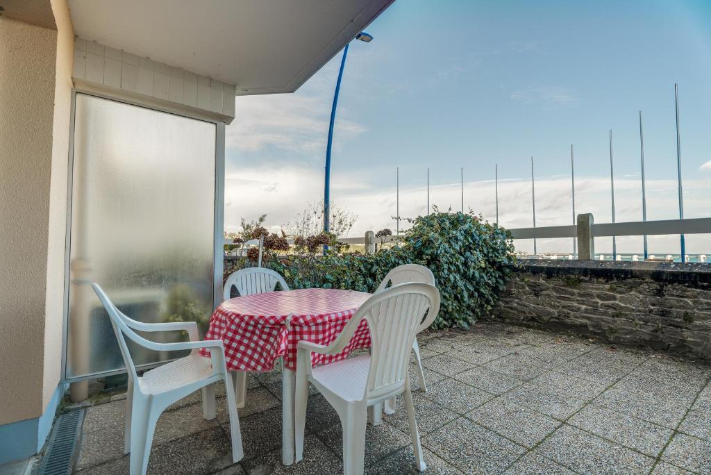 d'une table et de chaises sur un balcon avec vue sur l'océan. dans l'établissement Appartement vue Mer, à Saint-Cast-le-Guildo