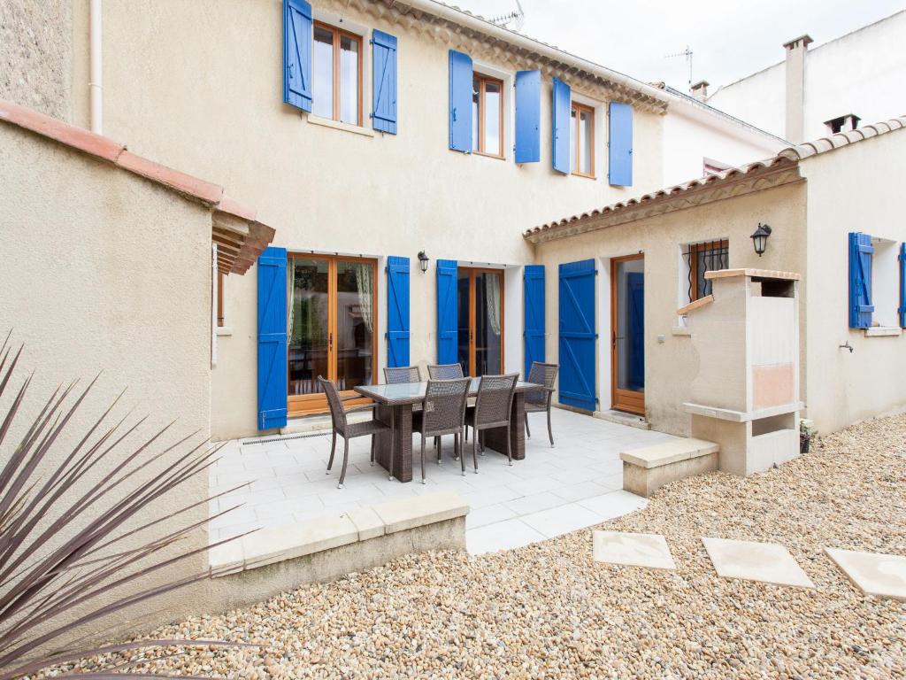 un patio avec une table et des chaises devant un bâtiment dans l'établissement Hirondelle - A beautiful rental home in the heart of The Cathar Country, à Capestang