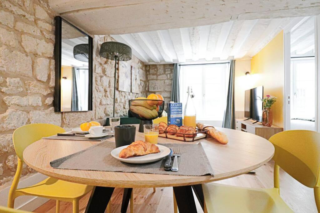 une table avec une assiette de nourriture dessus dans une pièce dans l'établissement 3p.cosy flat#6pers#heart of Le Marais, à Paris