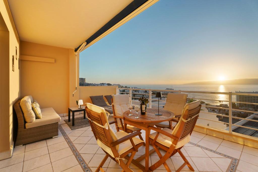 uma varanda com mesa e cadeiras e vista para o oceano em Great Sunset Views Los Gigantes em Acantilado de los Gigantes