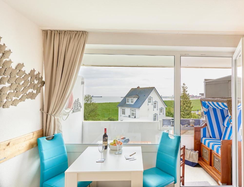 a dining room with a table and chairs and a window at Nautic - 306 in Cuxhaven