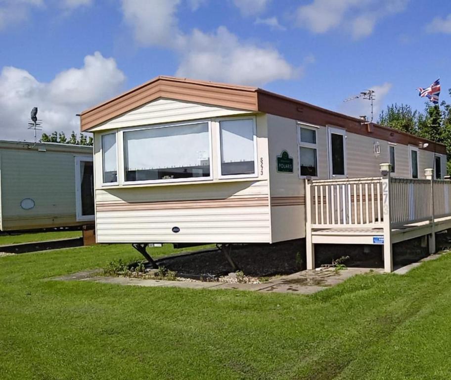 a tiny house sitting on top of a lush green field at Static caravan golden palm resort in Skegness