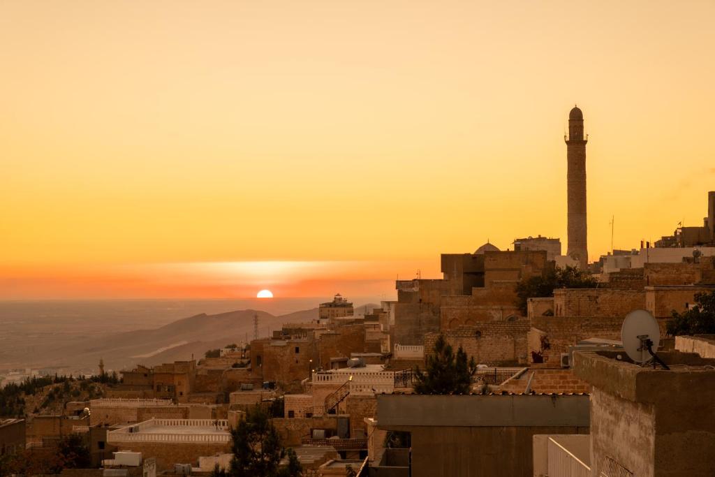 a sunset view of a city with a mosque at ELYANS KONAĞI in Mardin