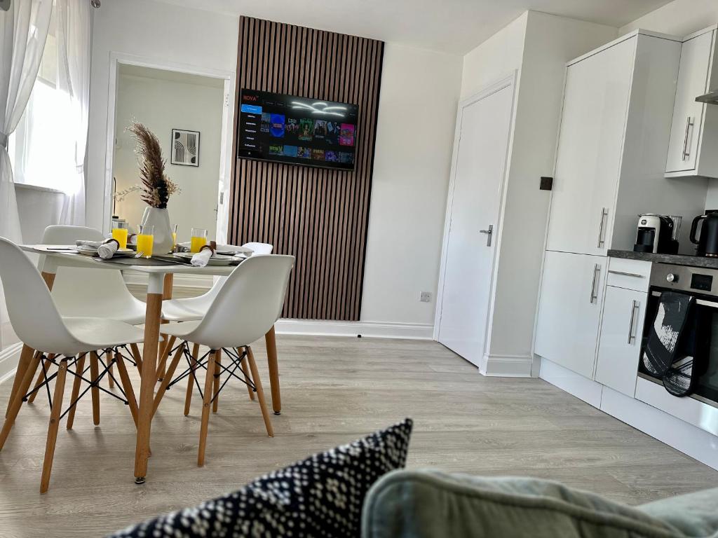 eine Küche und ein Esszimmer mit einem Tisch und Stühlen in der Unterkunft ASPIRE HOLIDAY HOMES in Bournemouth