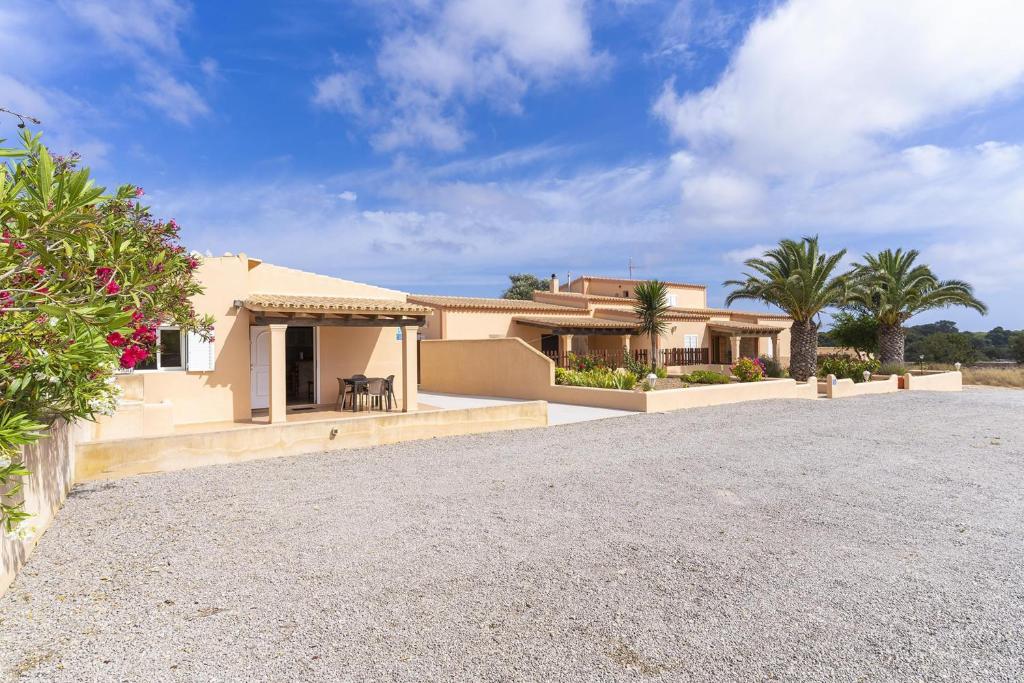 uma casa com palmeiras em frente a uma entrada em Can Juan De S'Hereu em Sant Francesc Xavier