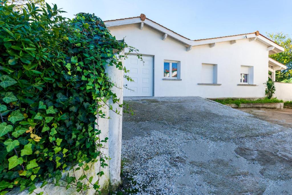 ein weißes Haus mit Garage in der Unterkunft Maison 3 chambres jardin 2km plage in Boucau