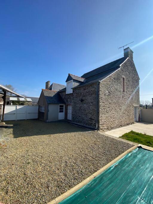 une maison en briques avec une piscine en face de celle-ci dans l'établissement Cancale « la ville es gris », à Cancale
