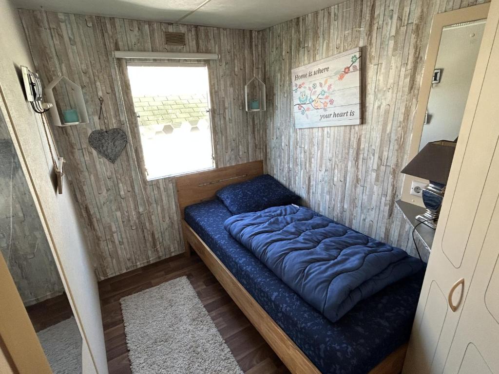 Ce lit se trouve dans une petite chambre dotée d'une fenêtre. dans l'établissement Roompot Beach Resort - 151, à Kamperland