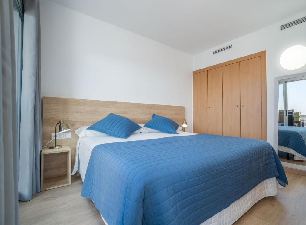 um quarto com uma cama azul e um cobertor azul em NIDO 380G em Roses