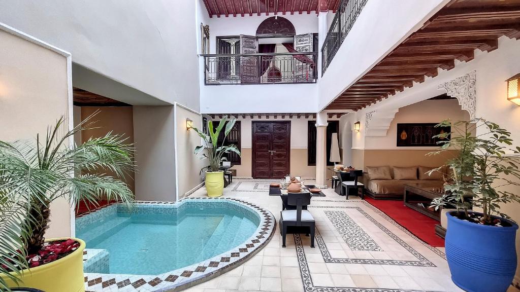 a pool in the middle of a house with plants at Riad Argan in Marrakesh