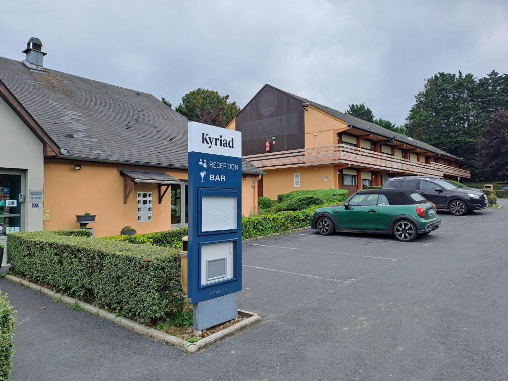 a fueling station in a parking lot next to a building at KYRIAD HONFLEUR - La Riviere Saint Sauveur in Honfleur