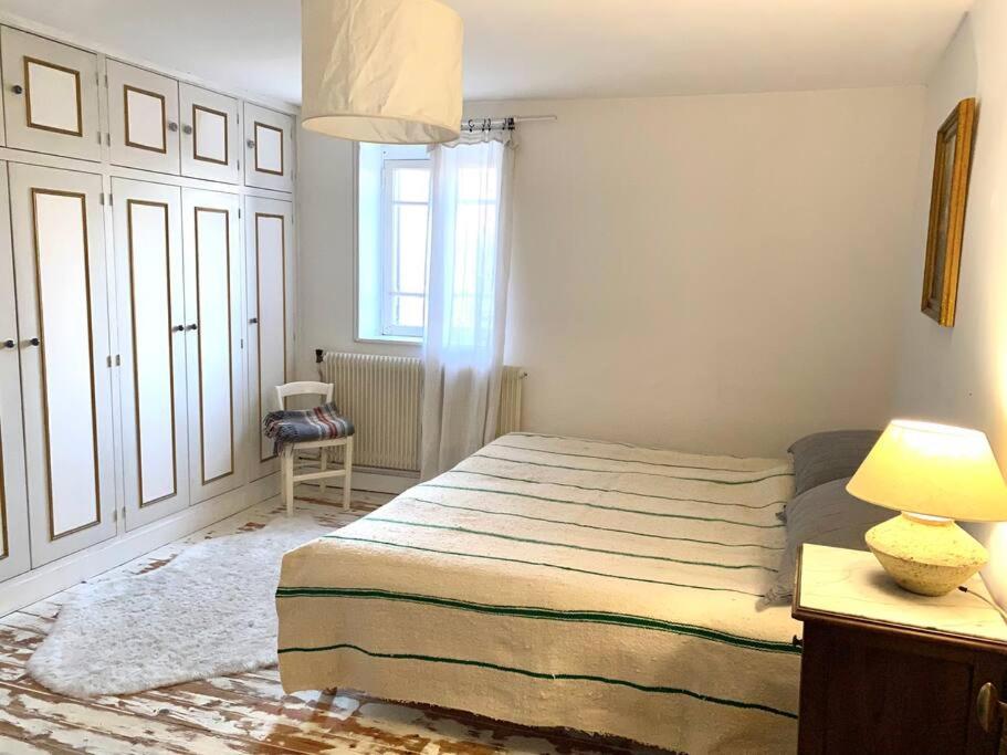 トゥルヴィル・シュル・メールにあるcharmante maison de pêcheurのベッドルーム1室(ベッド1台、ランプ付きテーブル付)