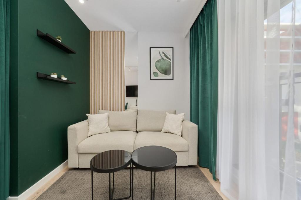 a living room with a couch and a table at Cosy Studio with access to Gym and Spa Area by Renters in Wrocław