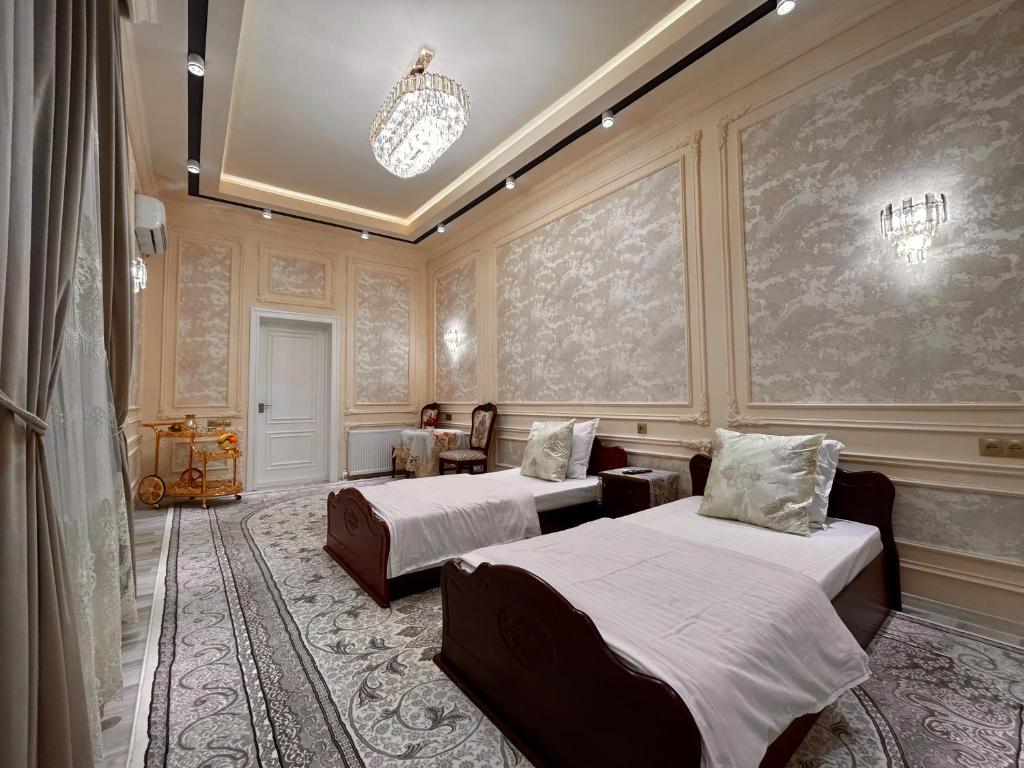 1 dormitorio con 2 camas y lámpara de araña en Guest house Comfort, en Samarkand