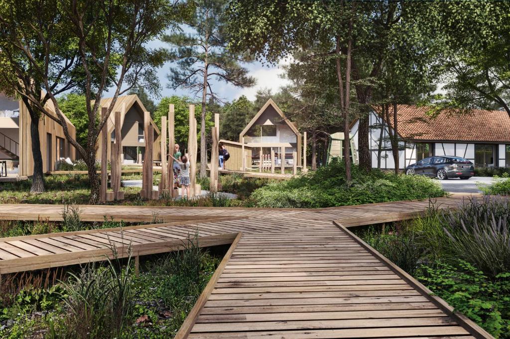 una pasarela de madera en un patio con casas en Woodz Lodges, en Heusden - Zolder