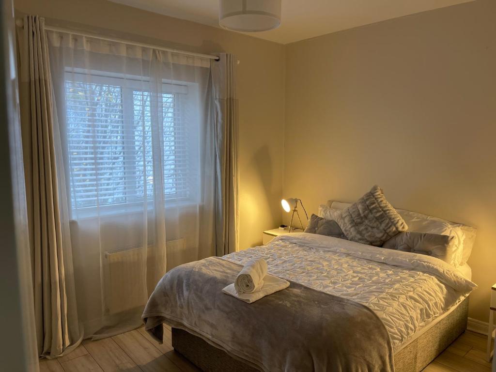a bedroom with a bed and a window with a hat on it at Letterkenny Three Bedroom Town Centre Apartment in Letterkenny