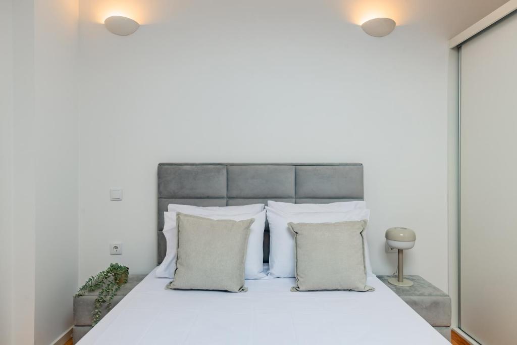 1 dormitorio con cama blanca y almohadas blancas en Pestana Cozy House, en Oporto