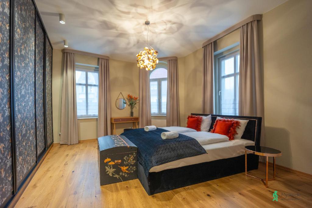 um quarto com uma cama e um lustre em Apartamenty z Duszą, MyWeek em Duszniki Zdrój