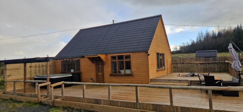 una pequeña casa de madera con terraza de madera en MT. Leinster View Cabin, en Enniscorthy