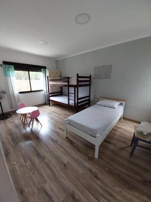 a bedroom with a bed and a table in it at Guidai Alojamiento in Tacuarembó