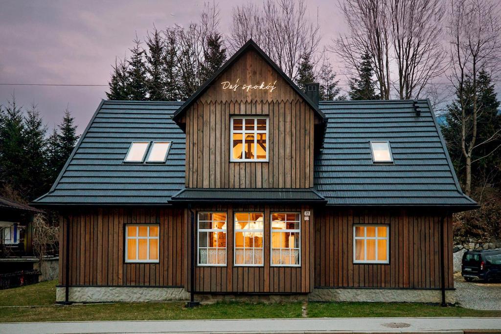 ein Haus mit einem schwarzen Dach und einem Fenster in der Unterkunft Daj Spokój in Szczyrk