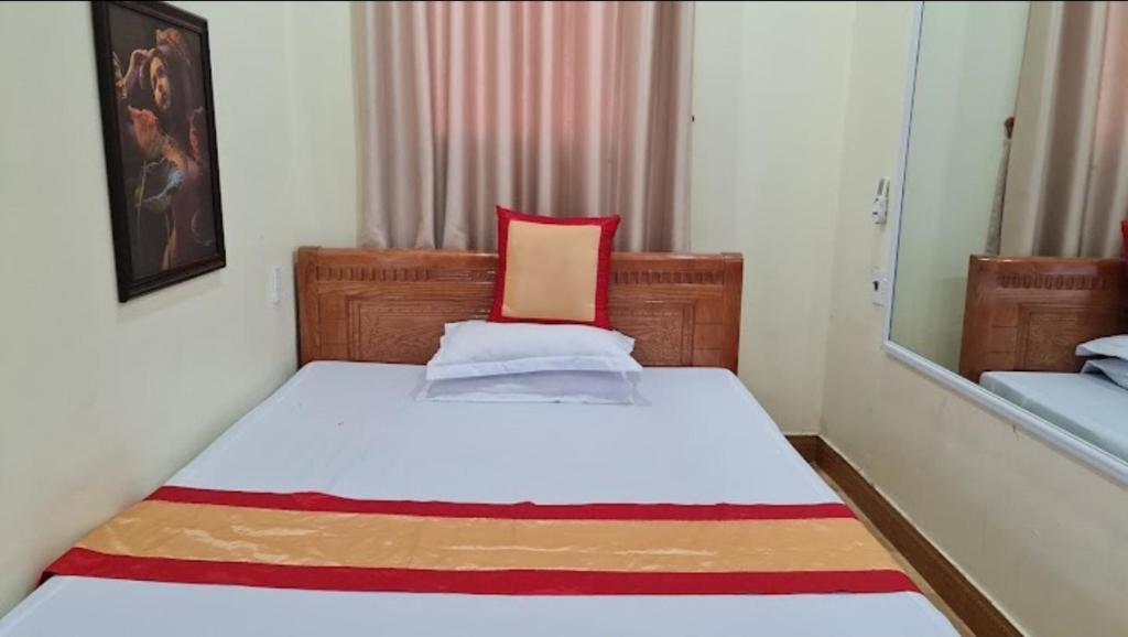 - une petite chambre avec un lit et un oreiller rouge dans l'établissement Nhà nghỉ Thu Hà, à Lạng Sơn