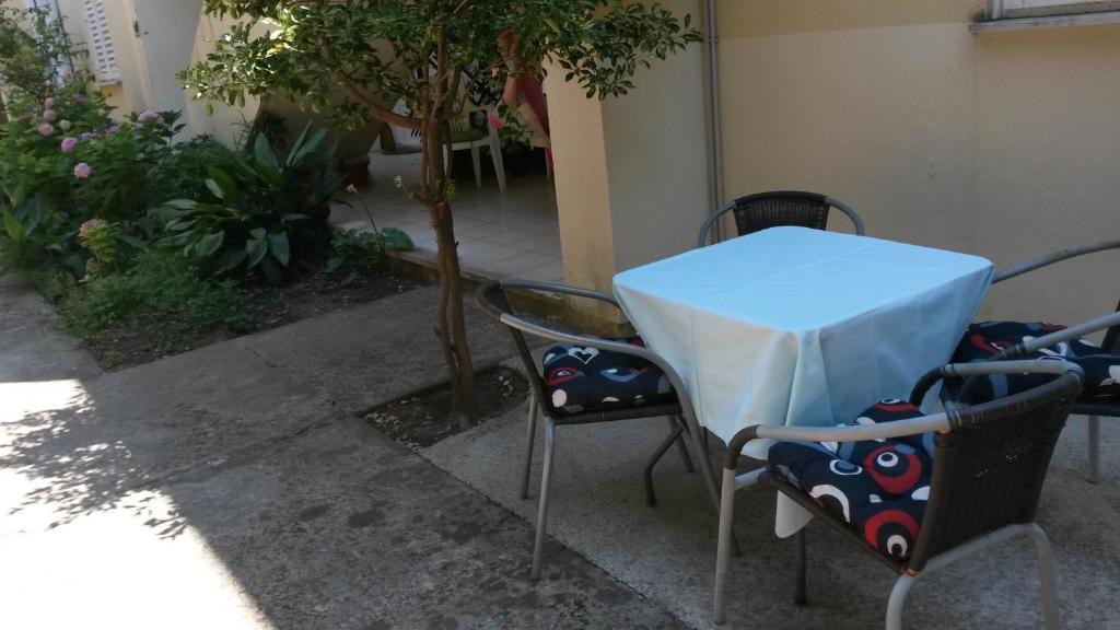 ein Tisch und Stühle mit einem blauen Tischtuch drauf in der Unterkunft Apartments Topolo Dubrovnik in Dubrovnik