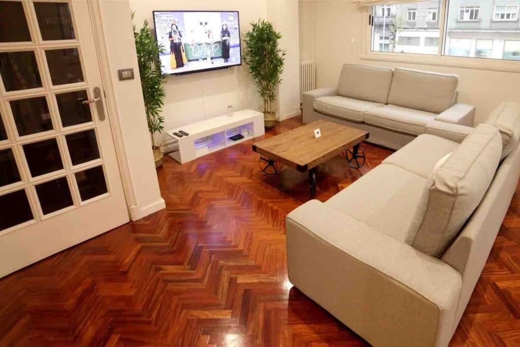 a living room with a couch and a table at Piso lujo en Gran Vía con garaje in Vigo