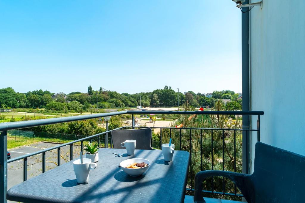 Les Thermes 421- Appt pour 4 avec piscine partagée في كونكارنو: طاولة زرقاء مع وعاء من الطعام على شرفة